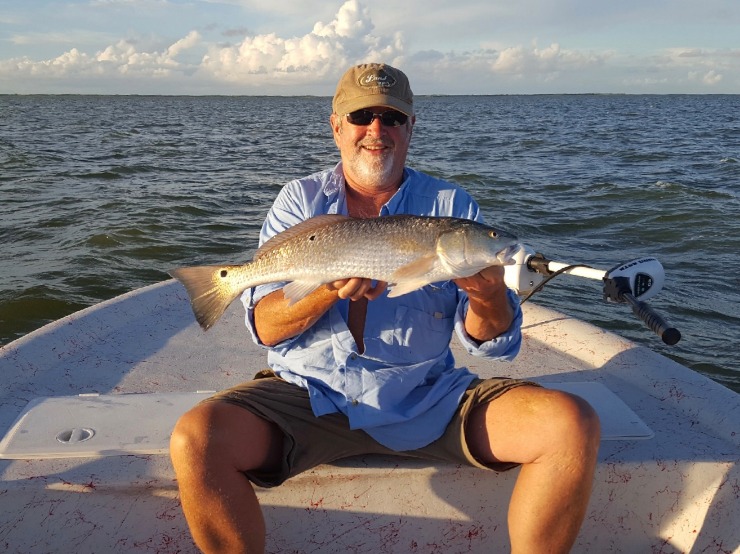 Grandpa-winter-with-redfish Captain Ryan's dad holding a large redfish and smiling